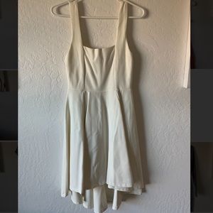 White dress, A-line with longer draped back.